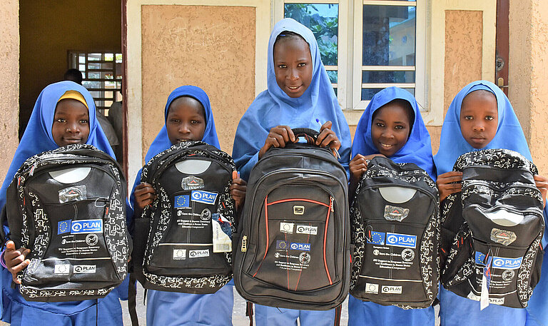 Mädchen haben Rucksäcke für den Schulbesuch erhalten